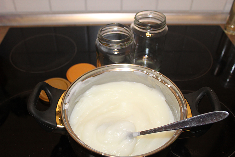 In de pan zie je de witte massa, op de achtergrond de potten om te vullen.