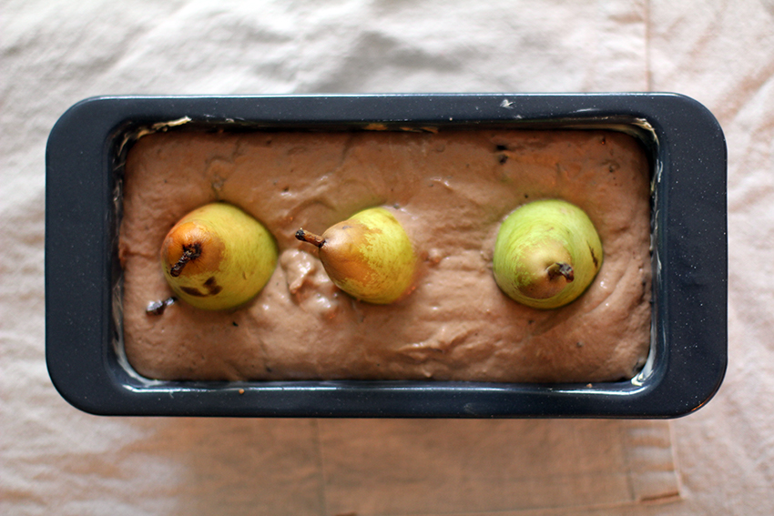 Drie peren zijn verzonken in het chocoladebeslag van de rode wijn cake.