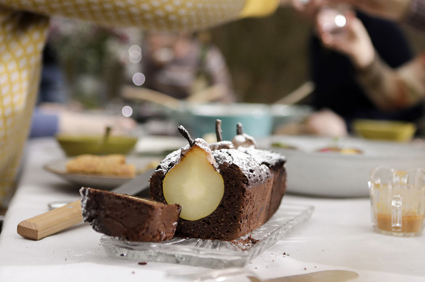 De zelfgemaakte perencake staat op een gedekte tafel.