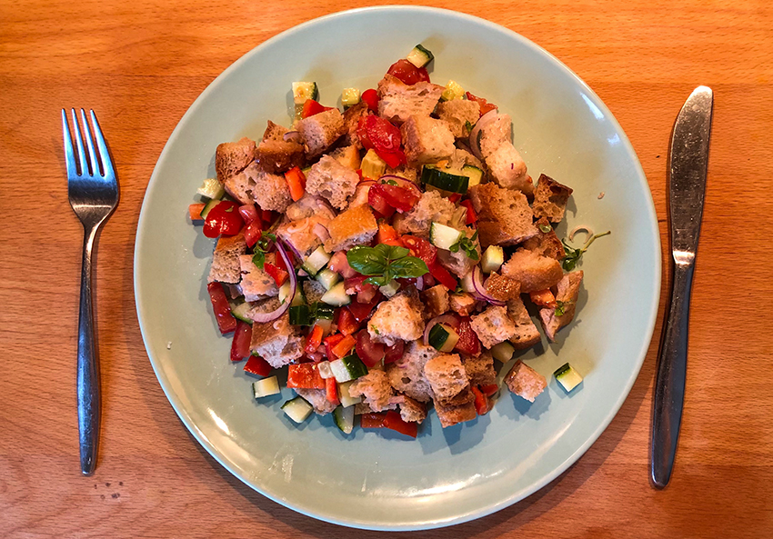 Brotsalat ist auf einem Teller angerichtet, mit dem Rezept kann man altes Brot verwerten.