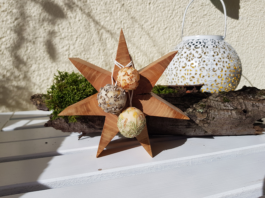 Aan een houten ster hangen drie kleine zelfgemaakte zeepjes