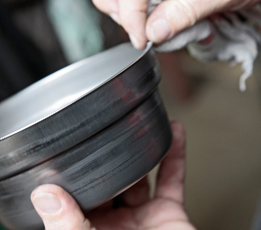 IJzeren container wordt in twee handen gehouden.